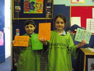 David Blitz and Ana Bernstein, both in Year 2 at North West London Jewish Day School, show off the Christmas and Chanukah cards they made for service personnel