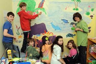 Volunteers from Edgware Reform and Norris Lea synagogues help paint a mural for Norwood