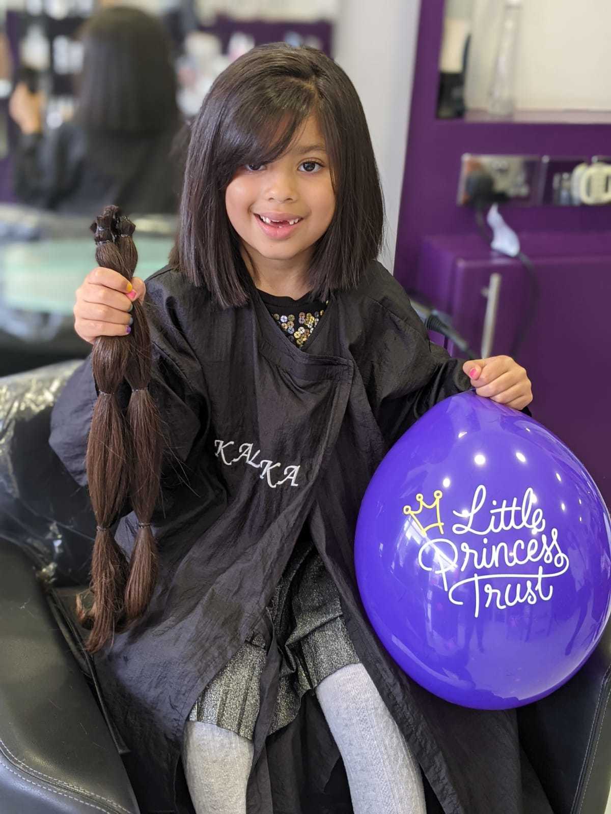 Nikki after her haicut and holding her hair that she is donating to the Little Princess Trust. Credit: Tina Nandha