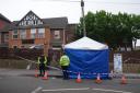 Police officers by a forensic tent at the scene of the attack in Luton (Lucy North/PA)