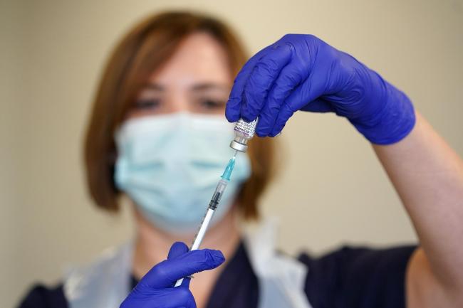 Nurse Heather Esmer draws a syringe before administering a Covid-19 vaccine booster at Birkenhead Medical Building in Merseyside