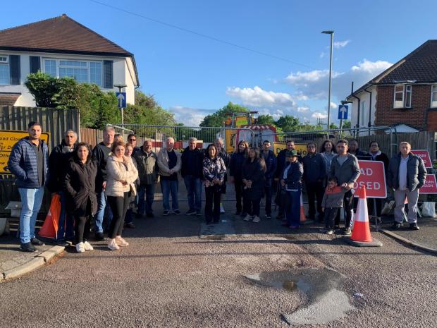 Borehamwood Times: Frustrated residents standing in front of Pike Road, which they want opened as a priority 