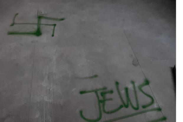 A symbol resembling a swastika was sprayed onto the floor of the house.